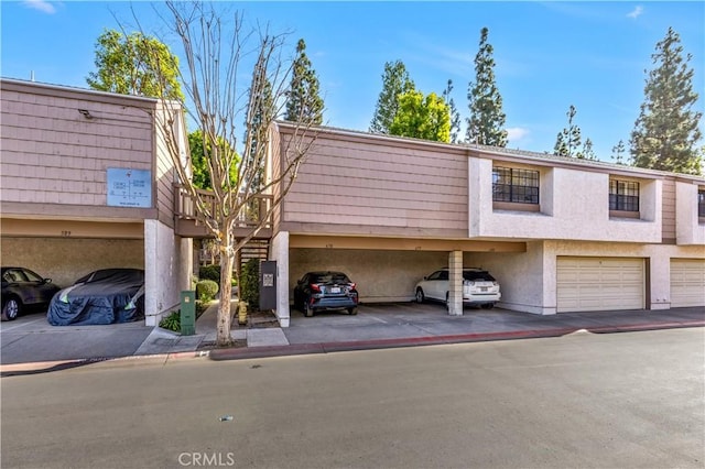 view of property with a carport and a garage