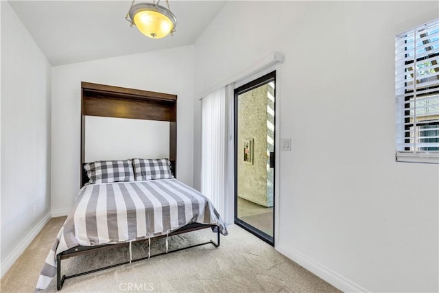 carpeted bedroom featuring lofted ceiling and access to outside