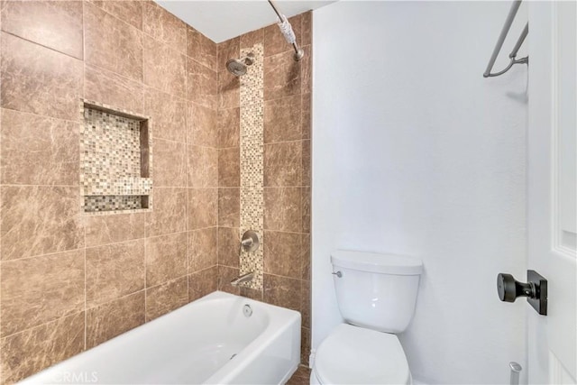 bathroom with toilet and tiled shower / bath combo