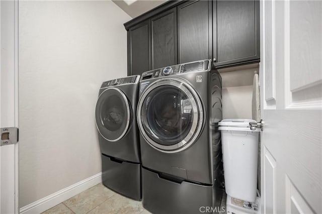 clothes washing area with cabinets, light tile patterned floors, and independent washer and dryer