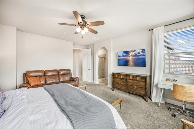 bedroom featuring ceiling fan, ensuite bath, and light carpet