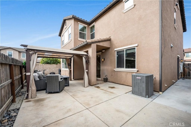 back of property with an outdoor living space, a gazebo, central AC, and a patio