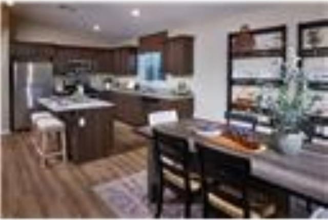 kitchen with dark brown cabinets, a breakfast bar, and a kitchen island