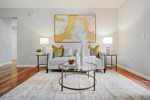 living area with hardwood / wood-style flooring and crown molding