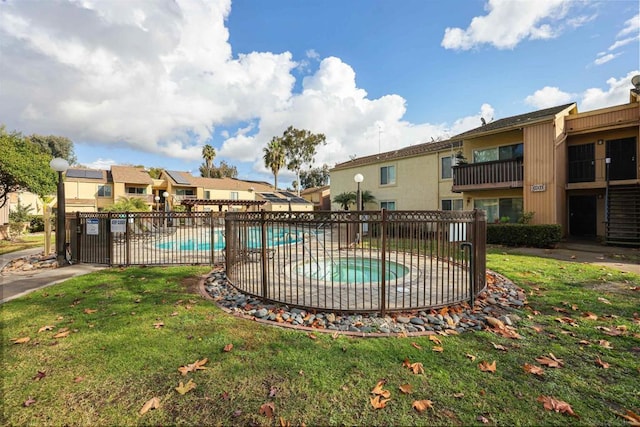 view of swimming pool with a community hot tub and a lawn