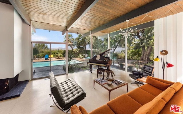 sunroom featuring beamed ceiling and plenty of natural light