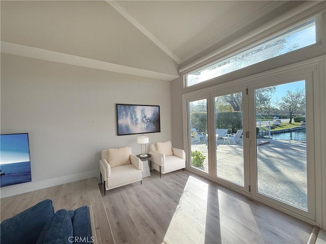 living area with high vaulted ceiling, light wood-style flooring, baseboards, and crown molding