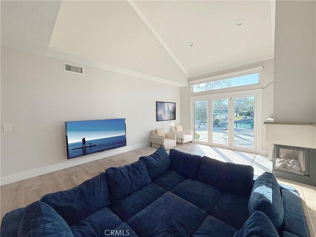 living room featuring ornamental molding, high vaulted ceiling, and hardwood / wood-style floors