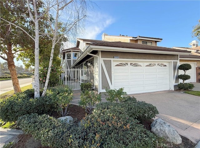 view of front of house with concrete driveway, an attached garage, and stucco siding