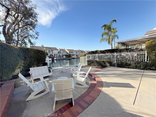 exterior space with a water view, fence, and a residential view