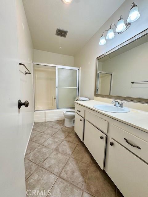 full bathroom with vanity, toilet, and combined bath / shower with glass door