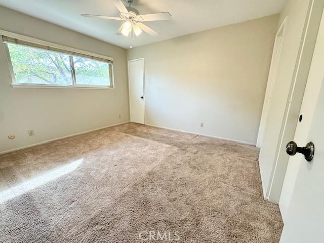 unfurnished bedroom featuring ceiling fan and light carpet