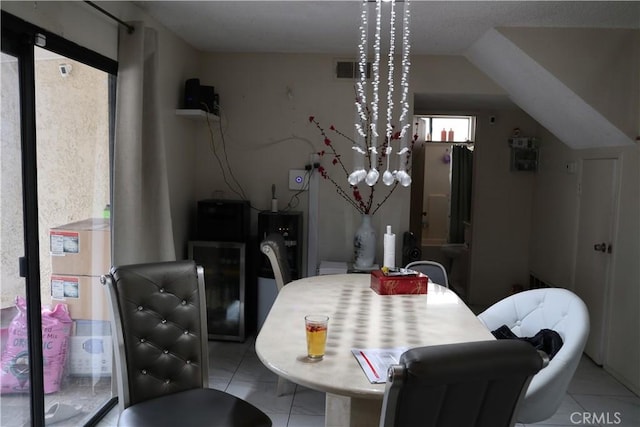 dining room with lofted ceiling and light tile patterned floors