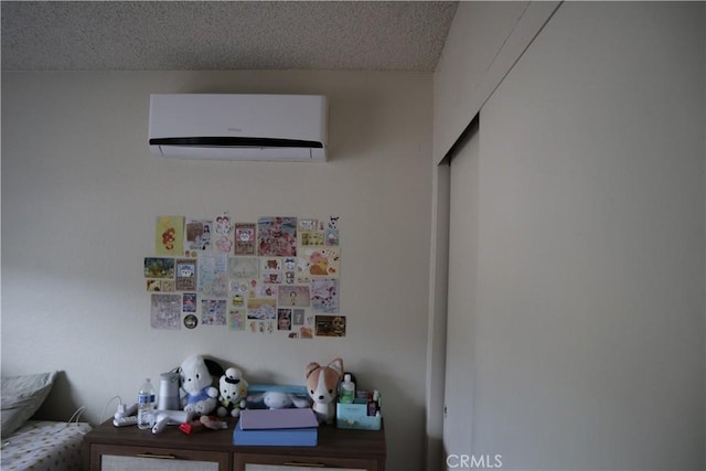 interior space with a wall unit AC and a textured ceiling