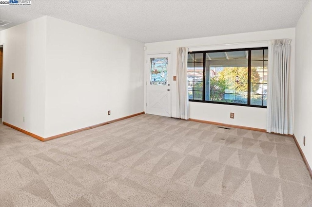 carpeted spare room featuring a textured ceiling