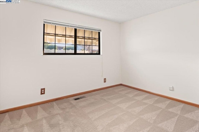 unfurnished room with carpet floors and a textured ceiling