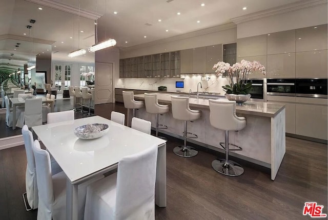 dining area with dark hardwood / wood-style flooring, sink, and ornamental molding