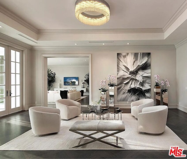 living room with a raised ceiling, dark hardwood / wood-style flooring, and french doors