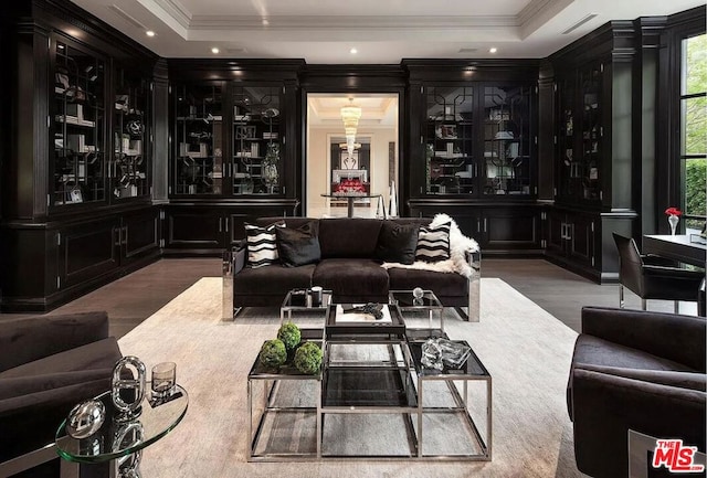 bar featuring crown molding, a raised ceiling, and hardwood / wood-style flooring