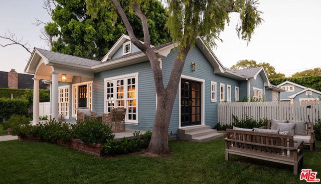 rear view of house featuring a lawn