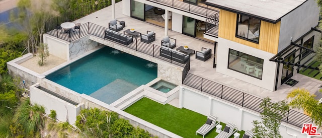 view of swimming pool featuring outdoor lounge area, a patio, and an in ground hot tub