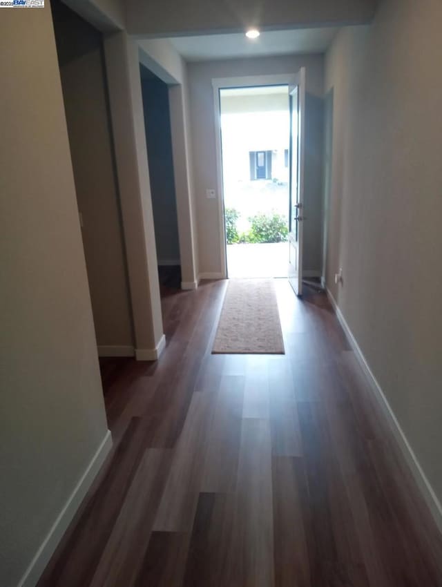 corridor with dark hardwood / wood-style flooring