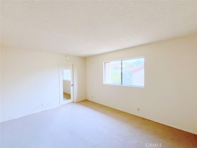 carpeted spare room with a textured ceiling