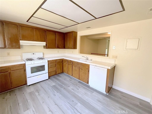 kitchen featuring white appliances, sink, and light hardwood / wood-style flooring