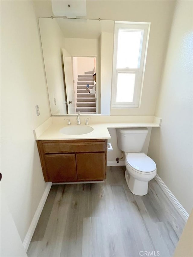 bathroom with vanity, wood-type flooring, and toilet