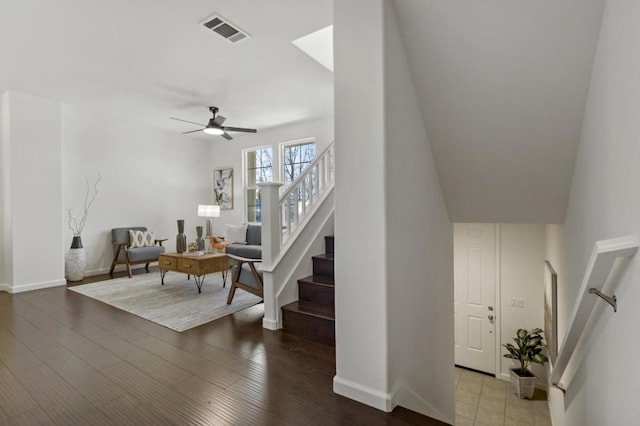 stairs with hardwood / wood-style flooring and ceiling fan