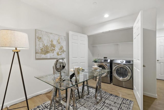 clothes washing area featuring washer and dryer and light hardwood / wood-style floors