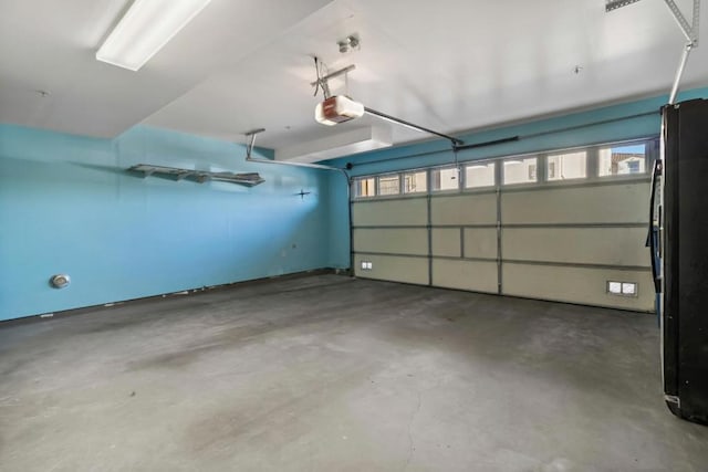 garage featuring black refrigerator and a garage door opener