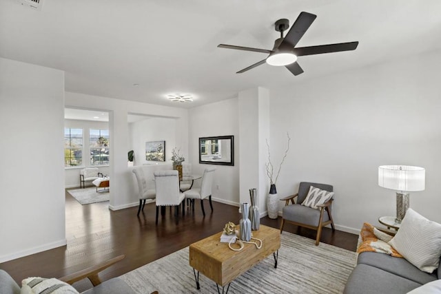 living room with ceiling fan and dark hardwood / wood-style flooring