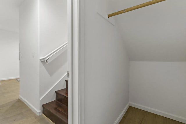 stairway with lofted ceiling and wood-type flooring