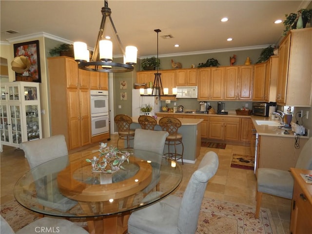 dining room with sink, ornamental molding, a chandelier, and light tile patterned flooring