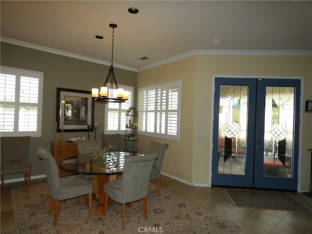 dining room with tile patterned flooring, crown molding, french doors, and a chandelier