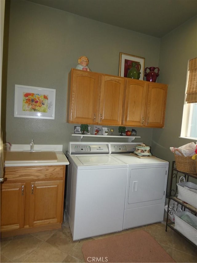 washroom featuring cabinets, washer and clothes dryer, and sink