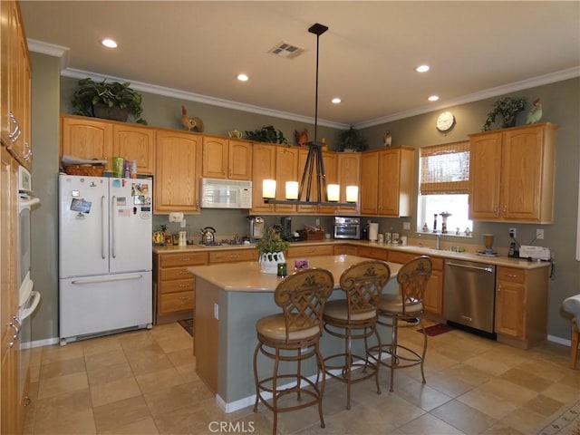 kitchen with a kitchen island, decorative light fixtures, a kitchen breakfast bar, crown molding, and white appliances