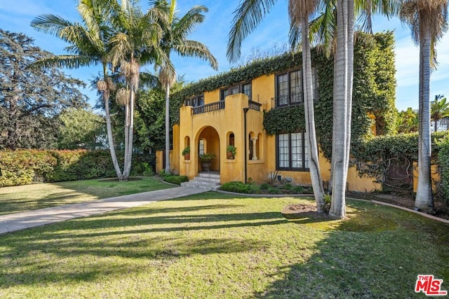 mediterranean / spanish-style home with a balcony and a front yard