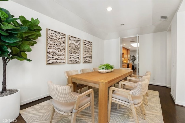 dining room with vaulted ceiling and dark hardwood / wood-style floors