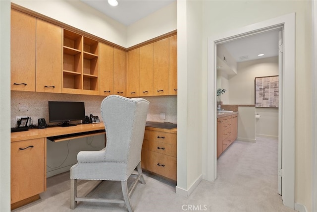 office featuring built in desk and light colored carpet