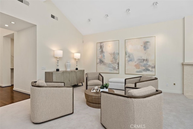 carpeted living room with high vaulted ceiling