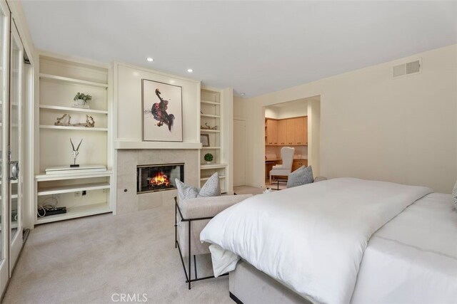 carpeted bedroom with a tile fireplace