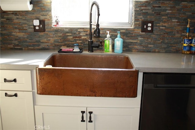 kitchen featuring tasteful backsplash, sink, and white cabinets