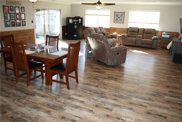 dining room with a wealth of natural light, dark hardwood / wood-style floors, and wood walls