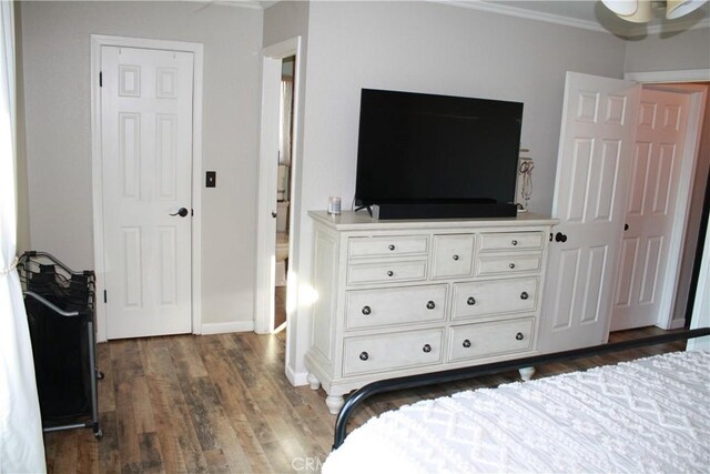 bedroom with ornamental molding and dark hardwood / wood-style floors