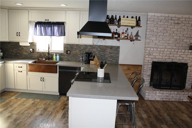 kitchen featuring sink, a breakfast bar, white cabinets, and island exhaust hood