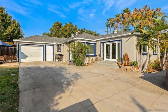 ranch-style house featuring a garage and french doors