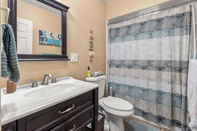 bathroom featuring vanity, walk in shower, and toilet