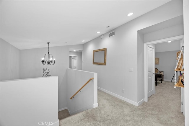 corridor with light carpet and an inviting chandelier